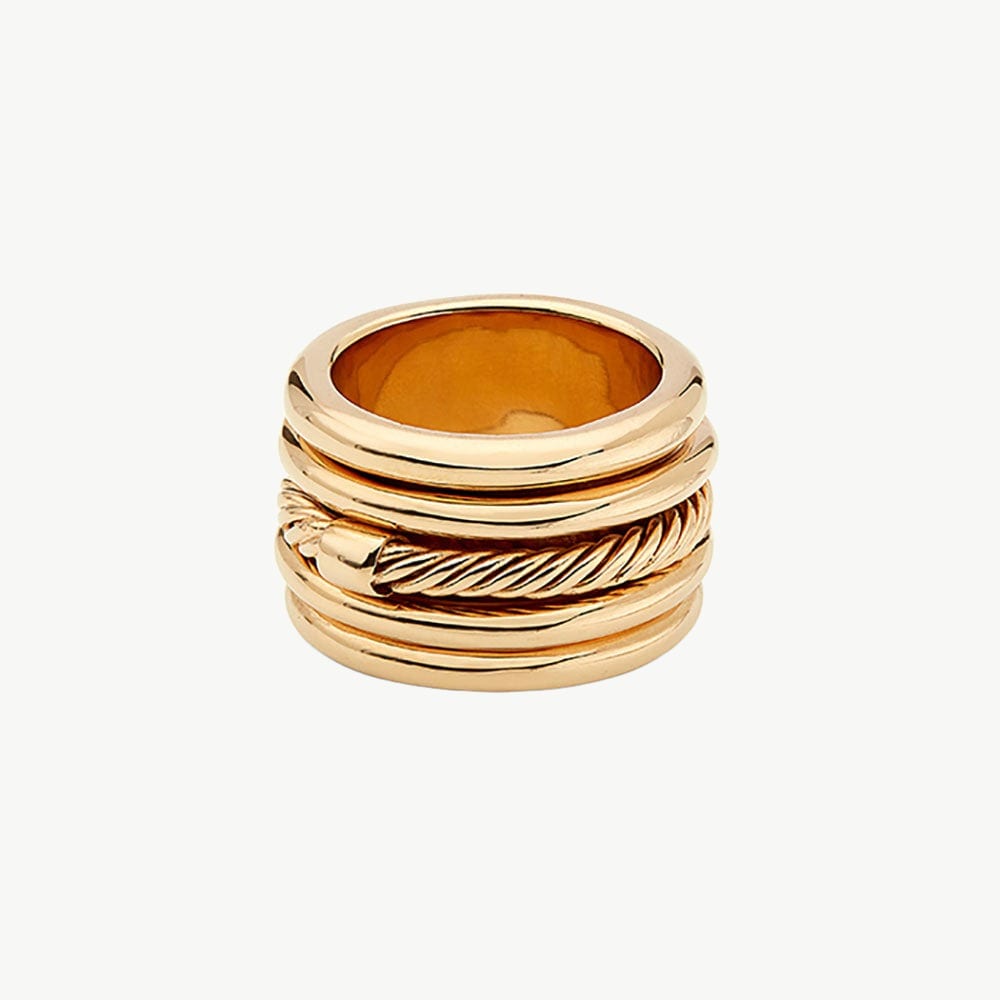 Gold-toned spinner ring with layered moving bands shown as a sculptural anchor object