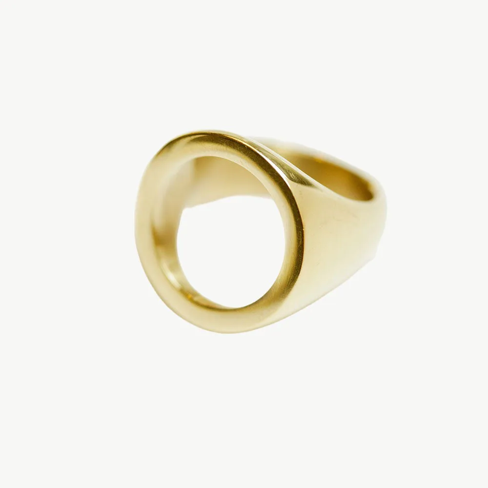 Open circle sculptural ring photographed alone so the central void and rounded contour remain clearly visible