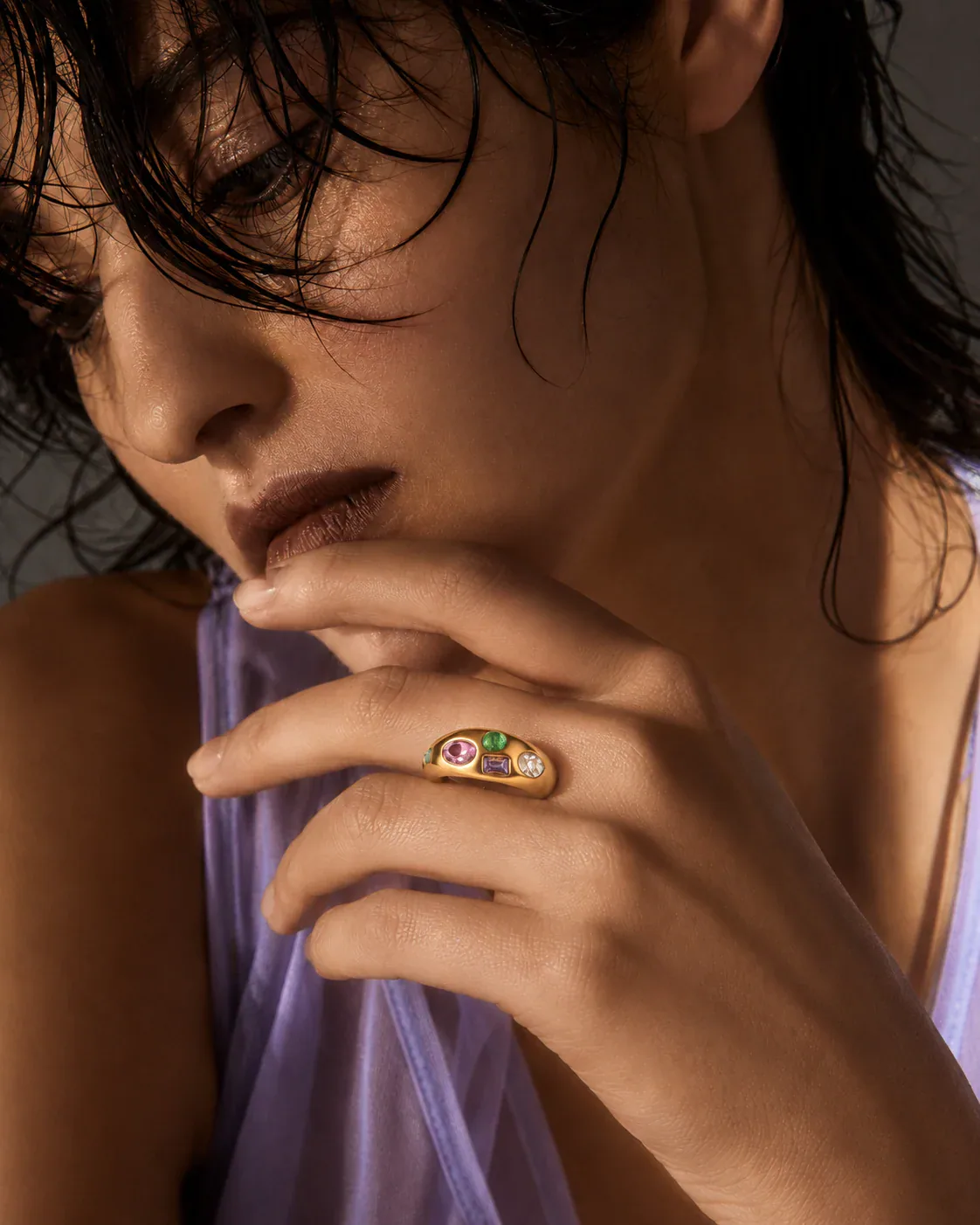 Adult Black model standing between reflective elevator doors, wearing a compact sculptural earring and architectural ring while holding a slim work case.