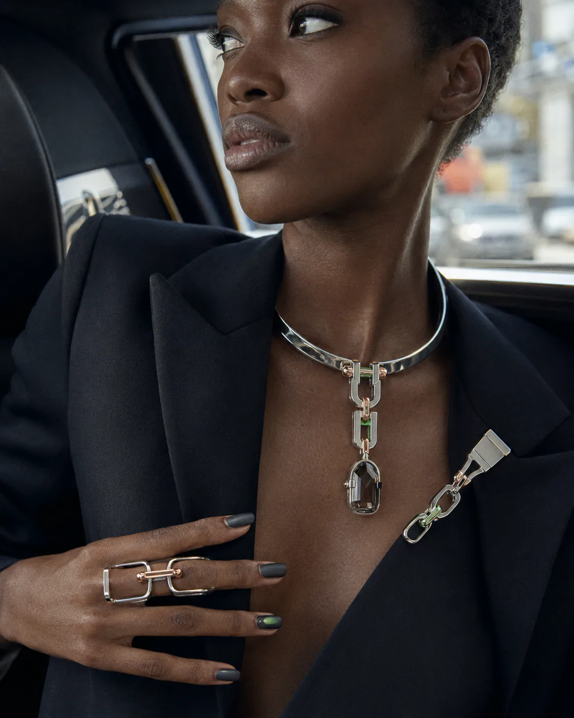 Polished sculptural silver jewelry with flowing curves worn in daylight