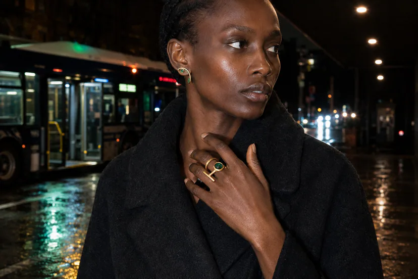 Sculptural rings and ear cuffs styled with minimalist clothing outside a cinema