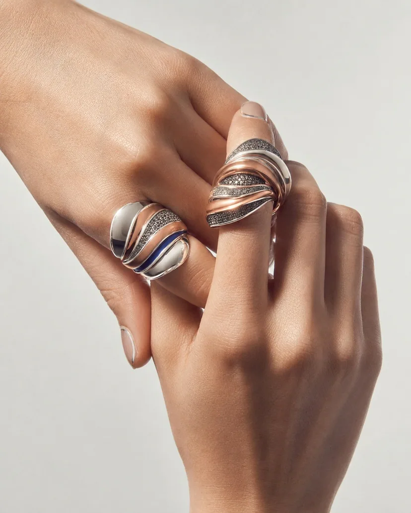 Press-on nails as miniature canvases styled on a hand with sculptural silver rings and chrome line details.