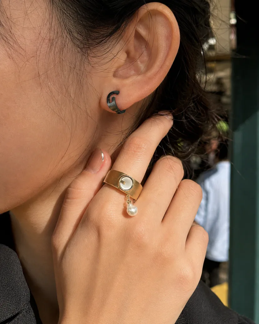 Editorial close-up of an adult model holding a striped ring form near the face