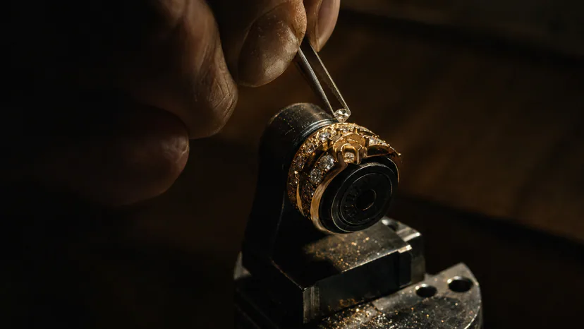 A jeweler setting a diamond into a gold ring; finished-jewelry claims must cover the stone, metal and manufacture.