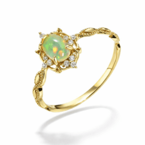 gold opal ring in gold vintage setting with diamond-like halo and leaf-detailed band, luminous oval opal centerpiece